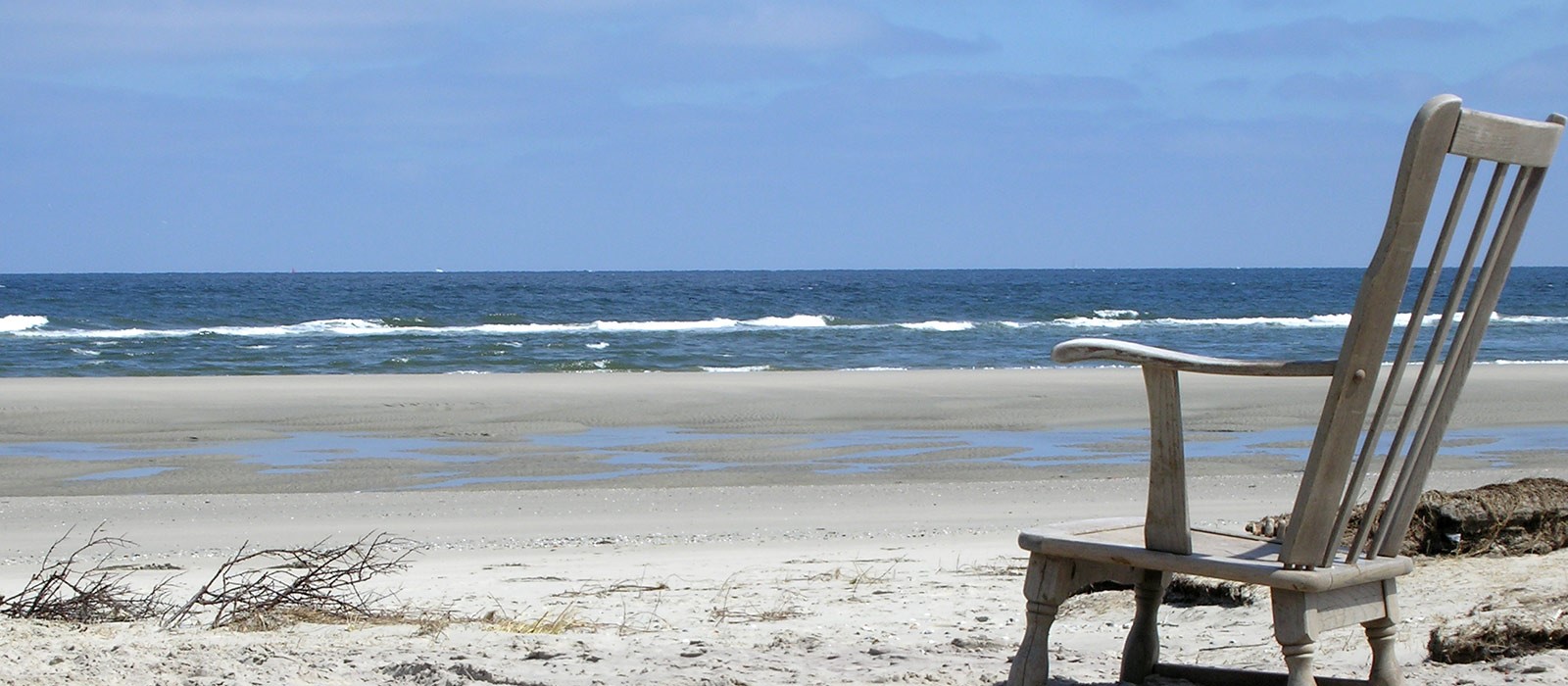 Lege houten leunstoel op strand met uitzicht op zee