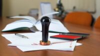 tafel met papieren en stempel notaris